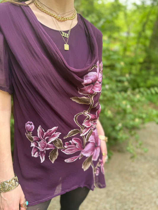 Close-up on the model of the draped neckline and the flower print running down one side