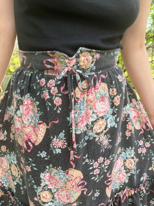 Close-up of the yoked waistband with a small bow at the front and the basket floral print