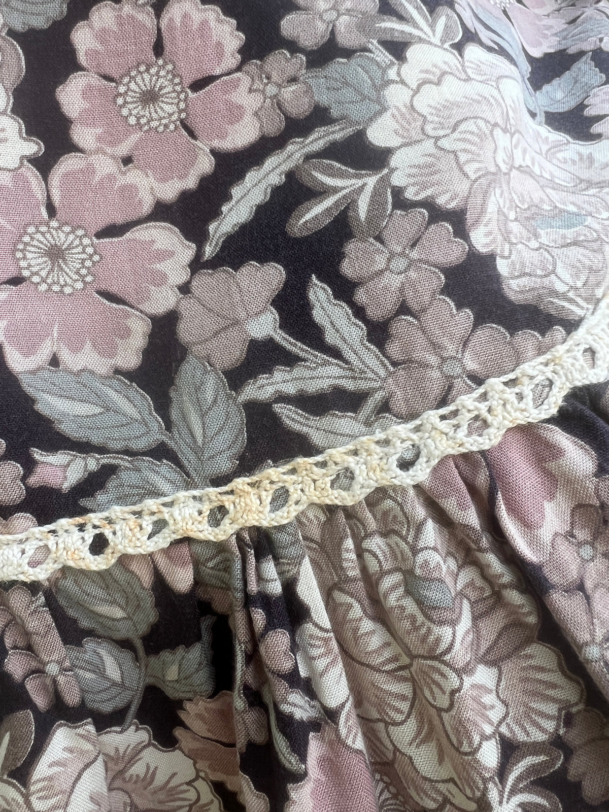 Close-up of the pink flowers and crocheted trim where the ruffle is gathered