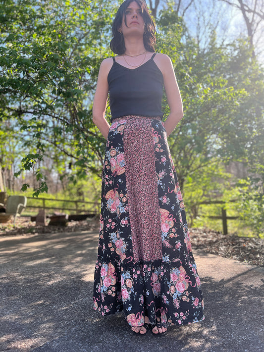 Full-length view on the model showing the long skirt, floral panels and ruffled hem