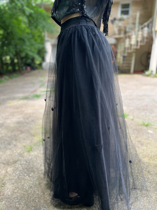 Side and back angle on the model showing the sheer overlay and rose decorations down the skirt