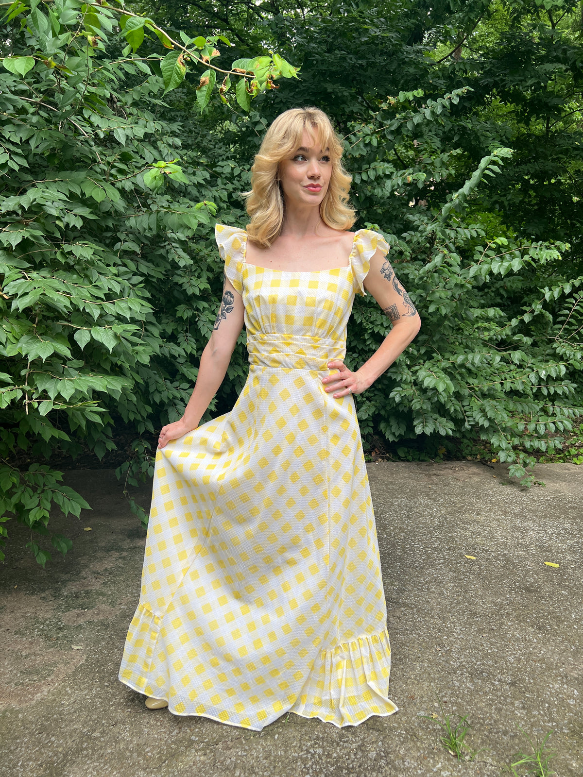 Yellow and white gingham Swiss dot maxi dress with a yoked waist and ruffled hem, worn by a model