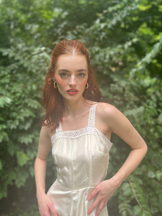 Close-up of the bodice on the model showing the eyelet lace edging along the neckline and straps