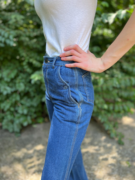 Close-up side view of the waistband and button side pocket on the model