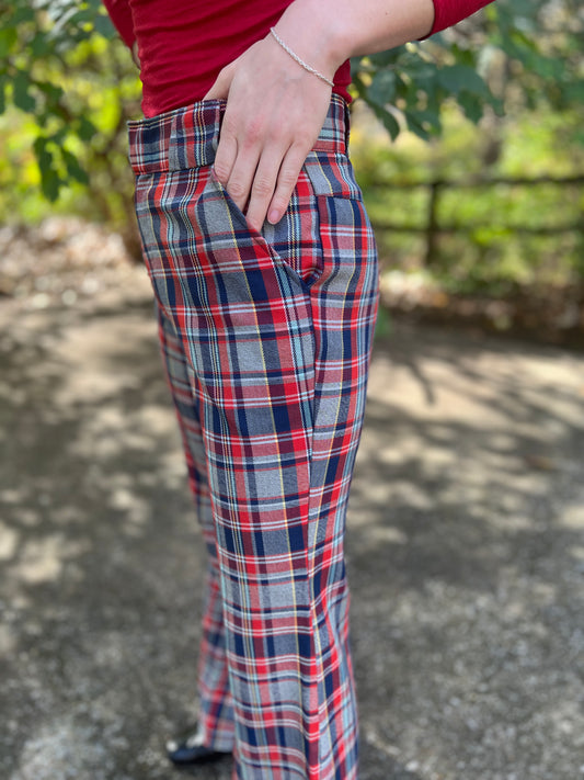 Angled view on the model with a hand in the front pocket, showing the plaid and the flare below the knee