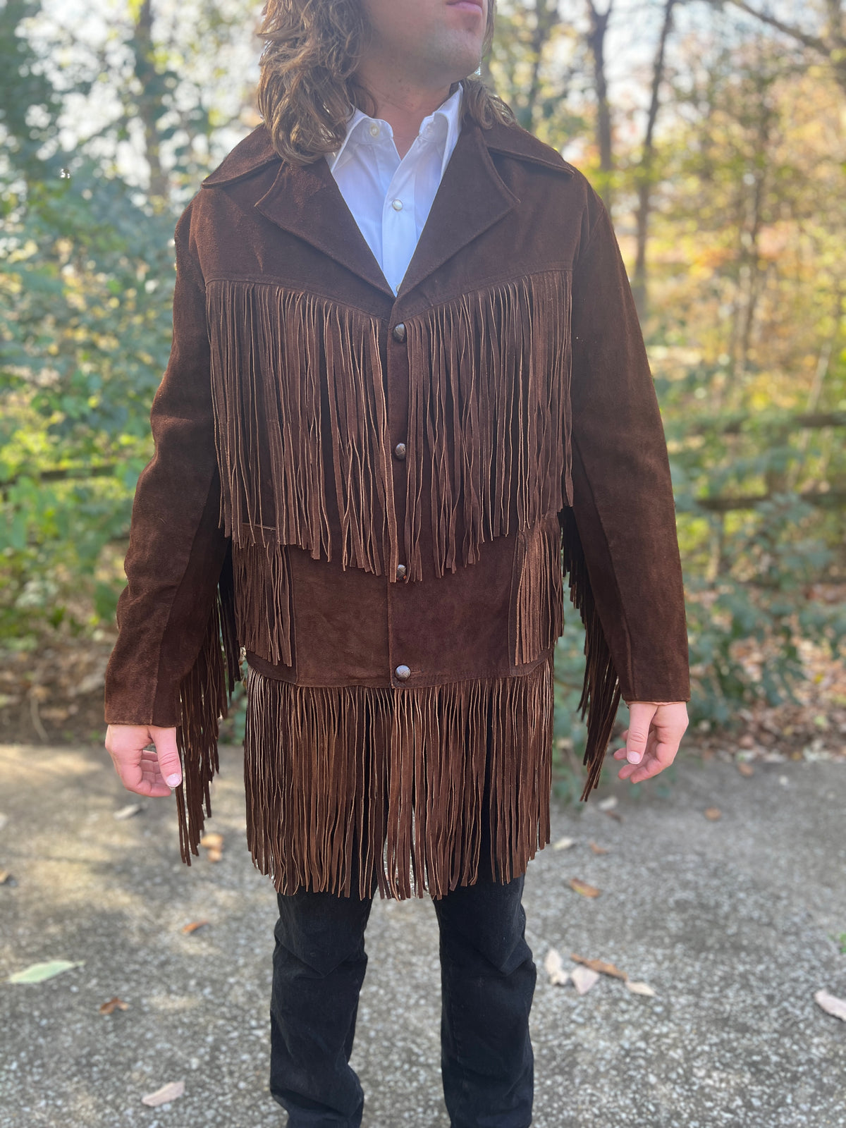Front view on the model showing the collar, four buttons and fringe on the shoulders, pockets and hem