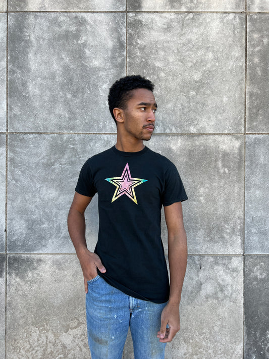 Angled front view on the model showing the glitter star on the black tee