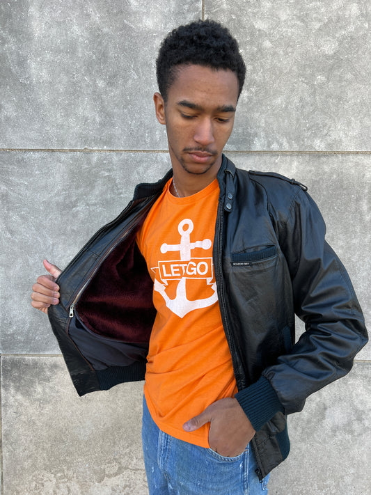 Orange anchor tee on the model under an open leather jacket