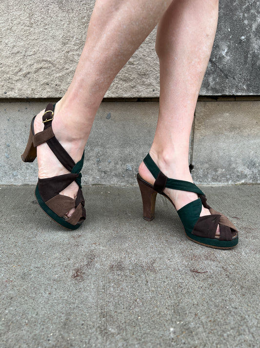 Both shoes on the model from the opposite side, showing the twisted straps, buckle and heels