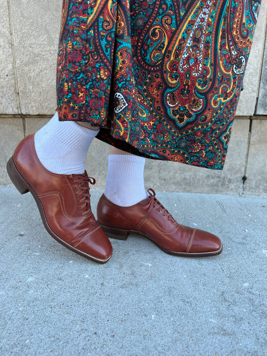 Both shoes on the model from the side, showing the toes, laces and low heels
