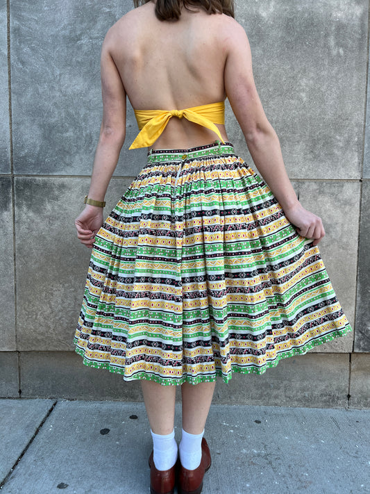 Back view on the model showing the stripes, waistband and zipper area, and the full gathered skirt