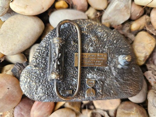Back of the belt buckle showing the belt loop and a plaque about 50 years of Bike Week