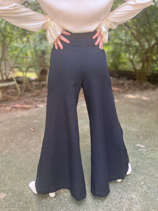 Back view on the model showing the high waist and the full length of the wide bell bottom legs