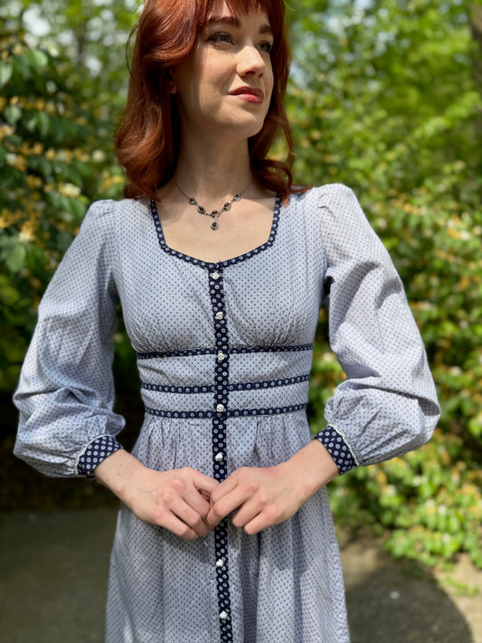 Close-up of the neckline, ribbon trim at the bodice, faux button front and sleeves