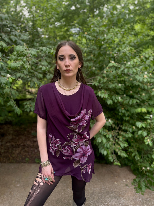 Sheer purple crepe top with a draped neckline and floral print, worn by a model