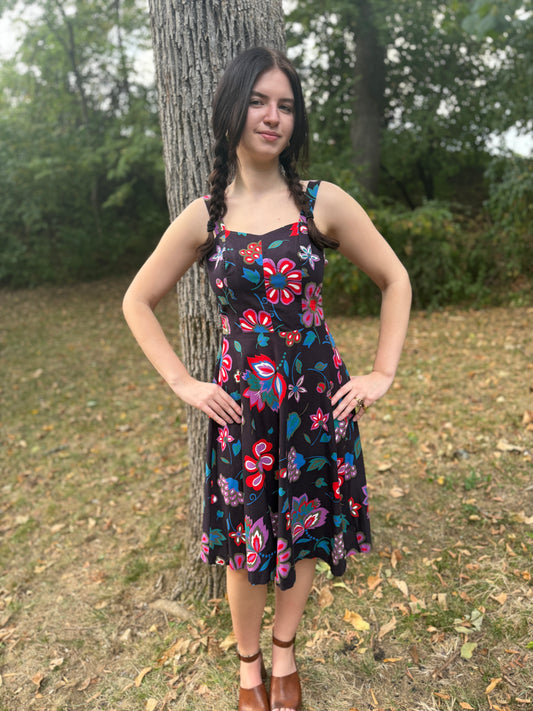 Black floral Aloha sundress with a fitted bodice and full skirt, worn by a model