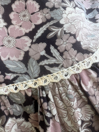 Close-up of the pink flowers and crocheted trim where the ruffle is gathered