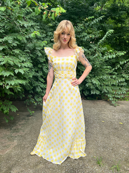 Full front view on the model, hand on hip, showing the bodice, waist and long skirt with ruffled hem