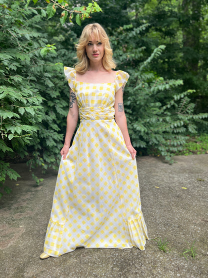 Front view on the model holding the skirt slightly out, showing the full skirt and hem ruffle