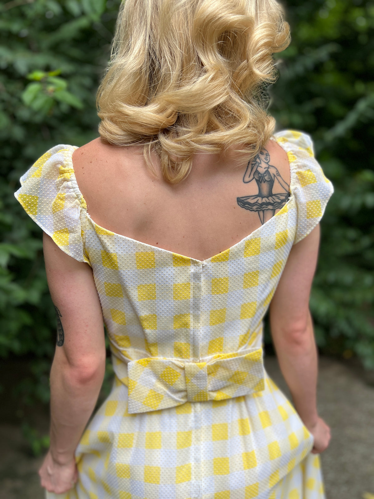 Close-up of the back on the model showing the center zipper and bow at the waist