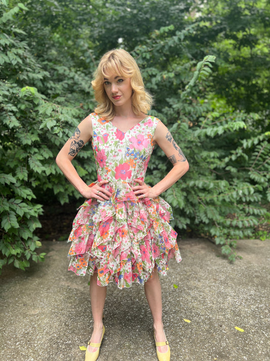 V neck dress in a pink and white floral print with a tiered skirt, worn by a model