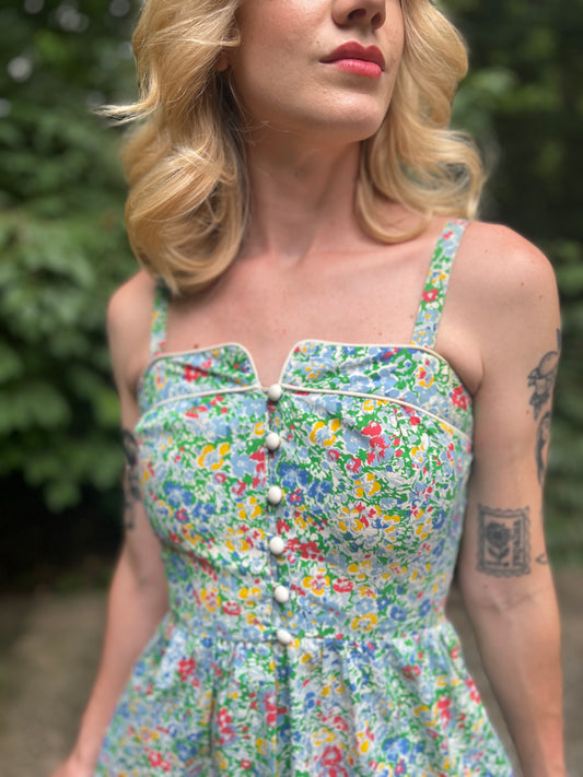 Close-up of the bodice showing the white piping, neckline, buttons and straps