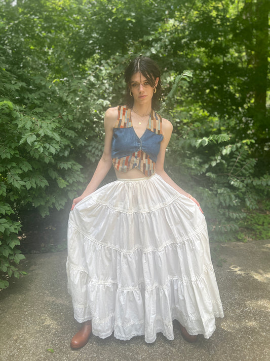 White cotton tiered maxi skirt with an eyelet hem, worn by a model