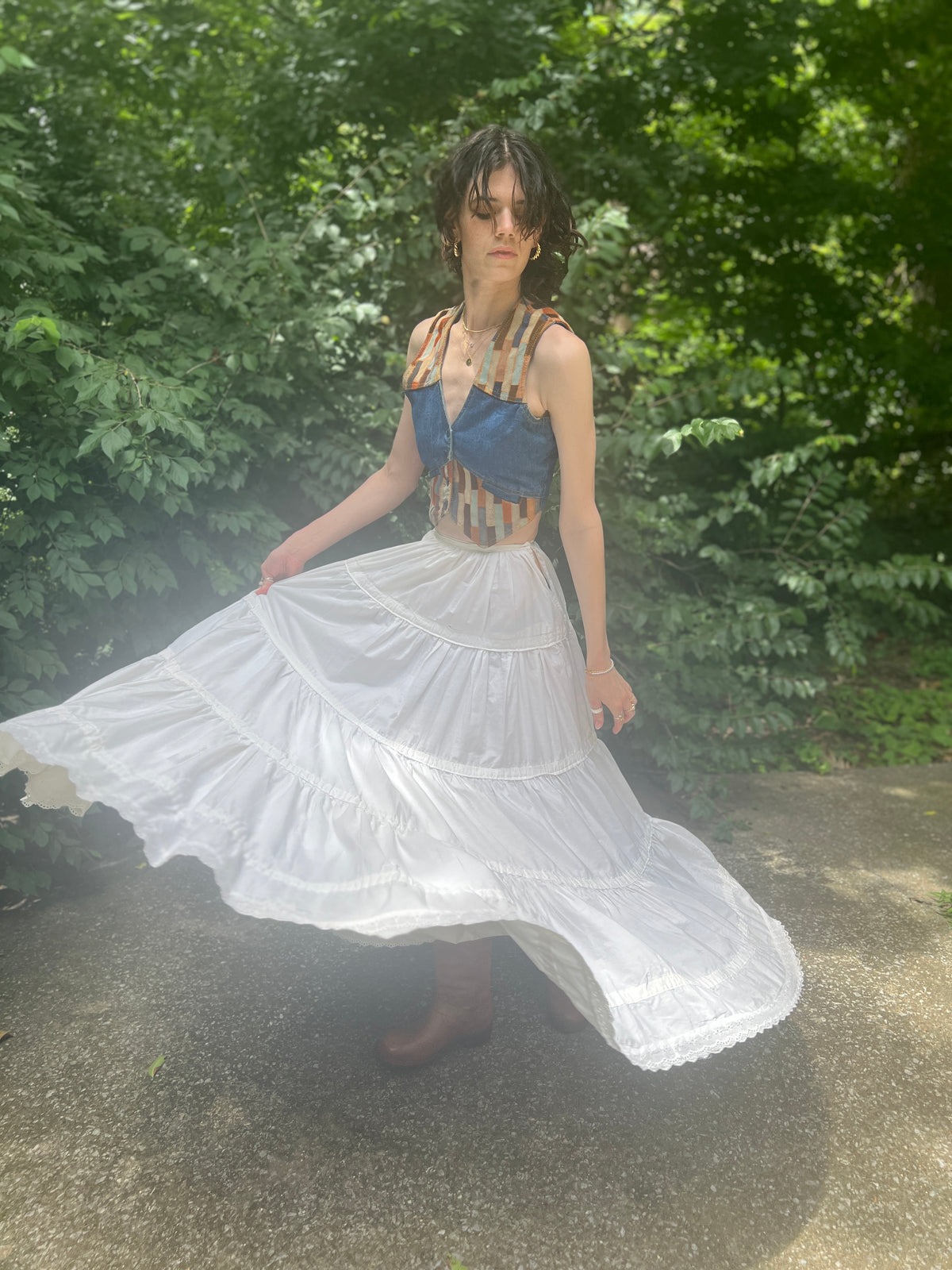 Model turning, skirt flaring wide to show the tiered layers and eyelet edging