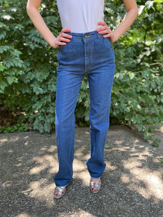 High-waisted denim jeans with a front zipper and button side pockets, worn by a model