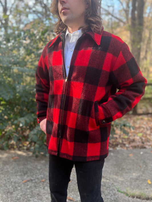 Black and red wool plaid jacket with a collar, zip front and button cuffs, worn by a model