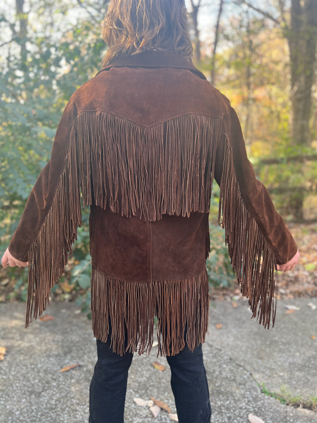 Back view on the model showing the fringed yoke, long fringe down the sleeves and fringed hem