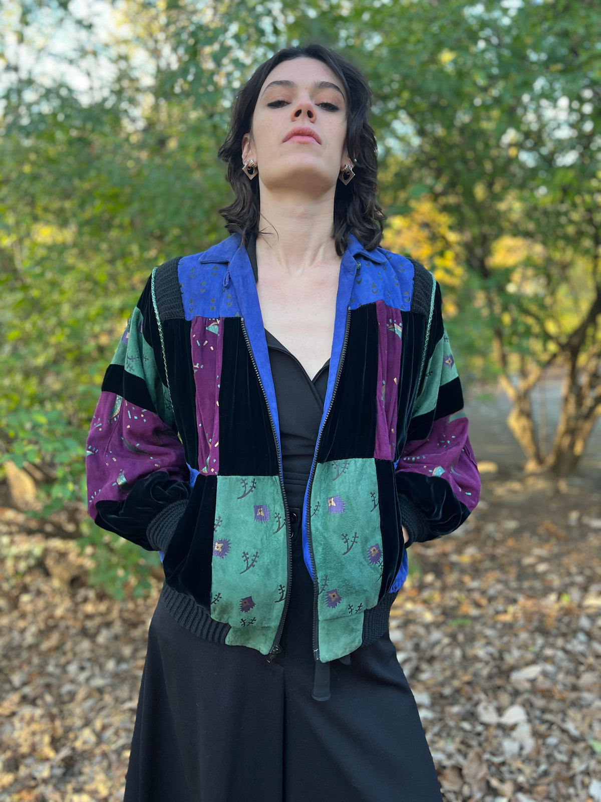 Closer front view on the model with the zipper partly open, showing the suede panels and sleeves