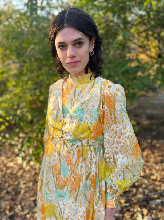 Close-up on the model of the high collar, front lacing and sheer sleeve with cuff
