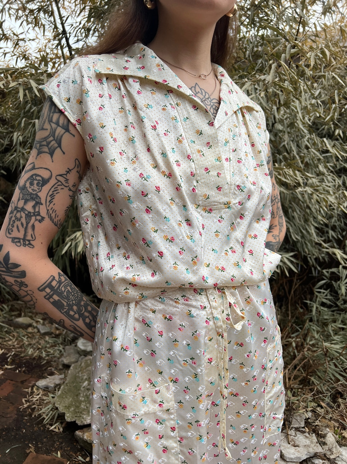 Angled view of the top and pants on the model showing the collar, front buttons, drawstring and pocket
