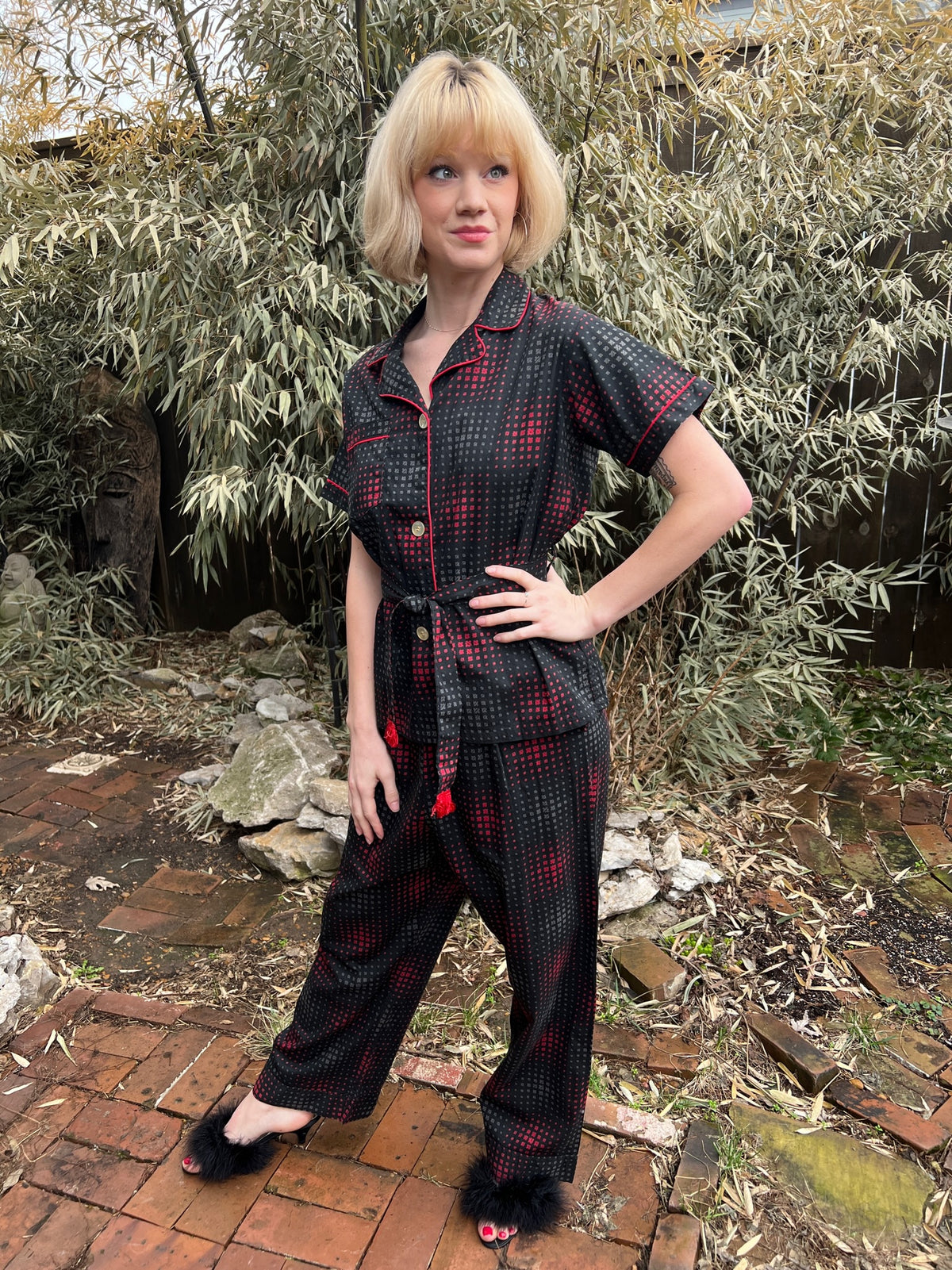 Full-length three-quarter view on the model showing the fringed belt and straight-leg pants