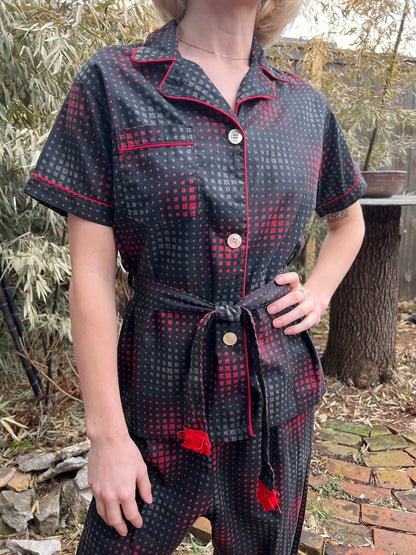 Close-up of the pajama top on the model showing the piped collar, pocket, buttons and fringed belt