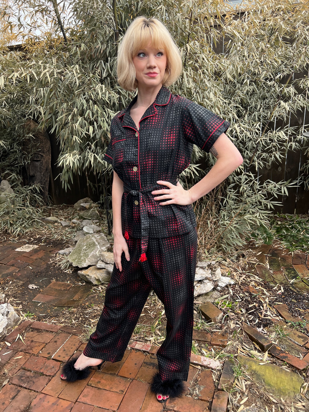 Black, red and gray cotton pajama set with red piping, short-sleeve top, fringed belt and straight-leg pants, on a model