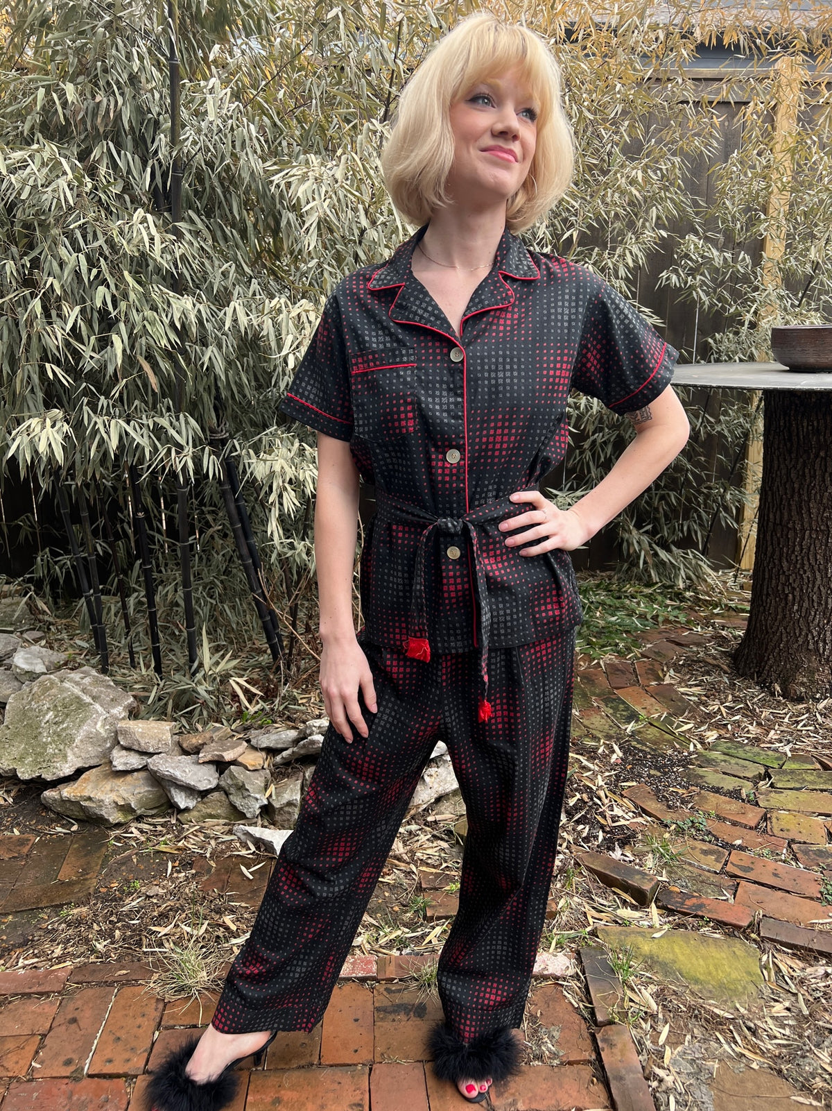 Full-length front view of the pajama set on the model, hand on hip, showing the top, belt and pants