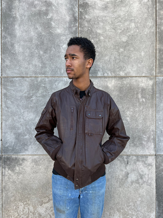 Brown leather zip-front jacket with a collar, zip pocket, flap chest pocket and knit waistband, worn by a model