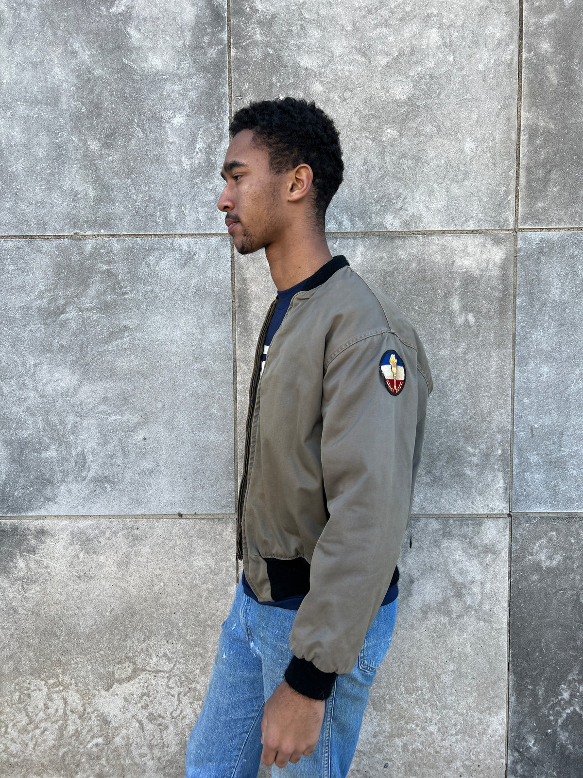 Side view on the model showing a round ROTC patch on the upper sleeve