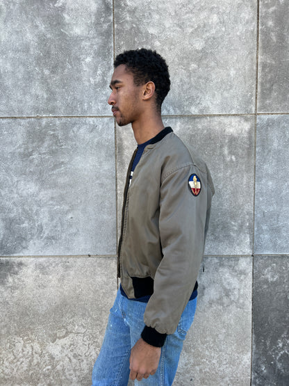 Side view on the model showing a round ROTC patch on the upper sleeve