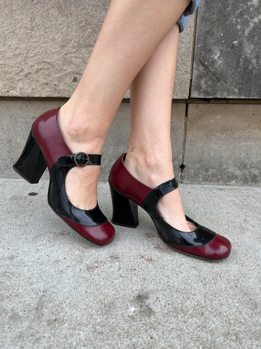 Both shoes on the model from the side, showing the strap and chunky heels
