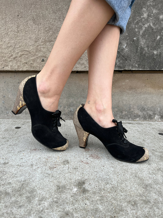 Opposite side views of both shoes on the model showing the laces, reptile heels and toe caps
