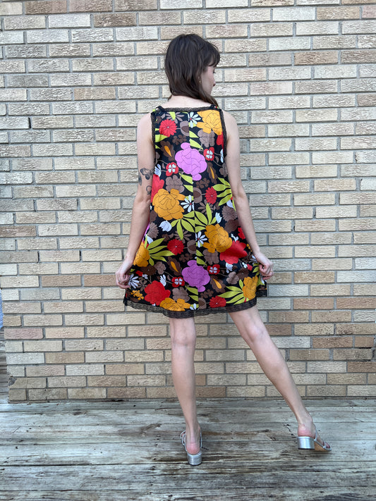 Back view on the model with the head turned, showing the floral print and black lace trim