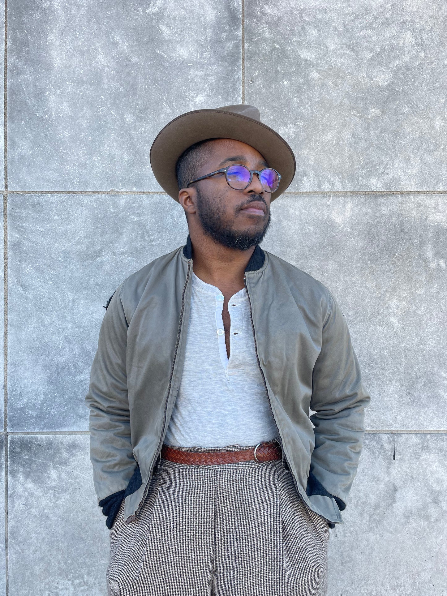 Khaki brown zip front bomber style jacket with knit collar and cuffs, worn open over a henley by a model