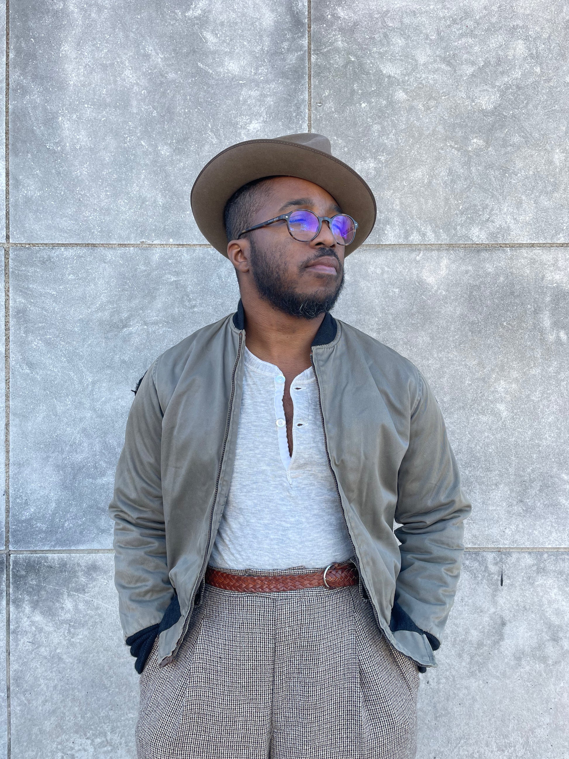 Khaki brown zip front bomber style jacket with knit collar and cuffs, worn open over a henley by a model