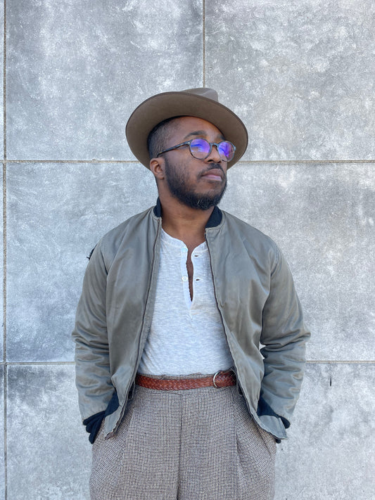 Khaki brown zip front bomber style jacket with knit collar and cuffs, worn open over a henley by a model