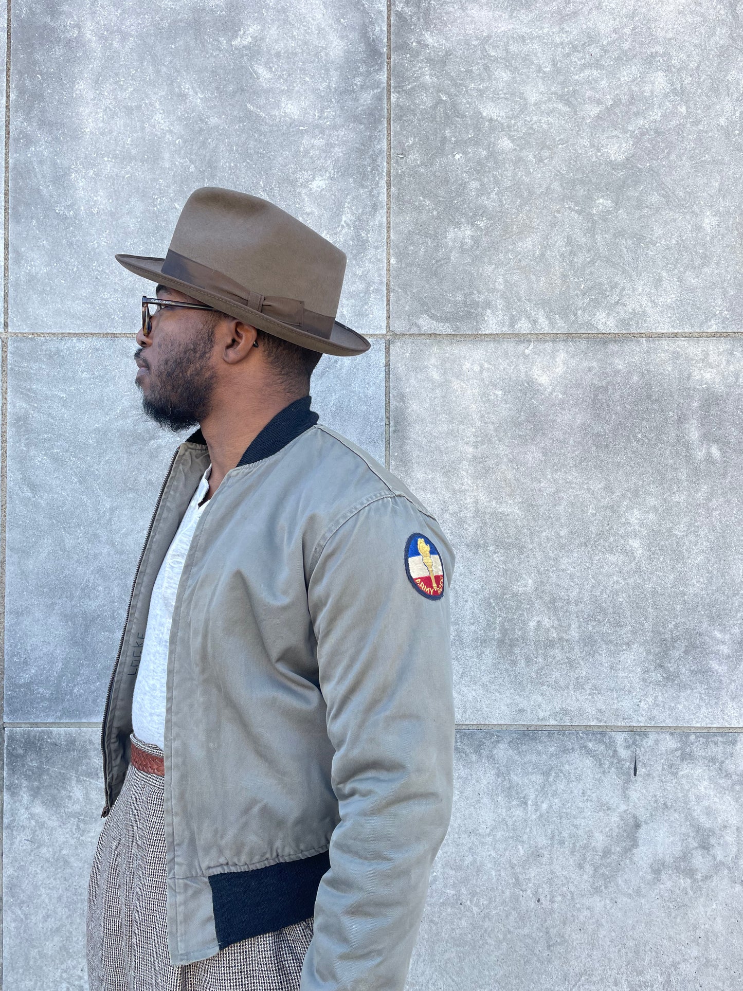 Side view on the model showing a round ROTC patch on the upper sleeve and the zip front