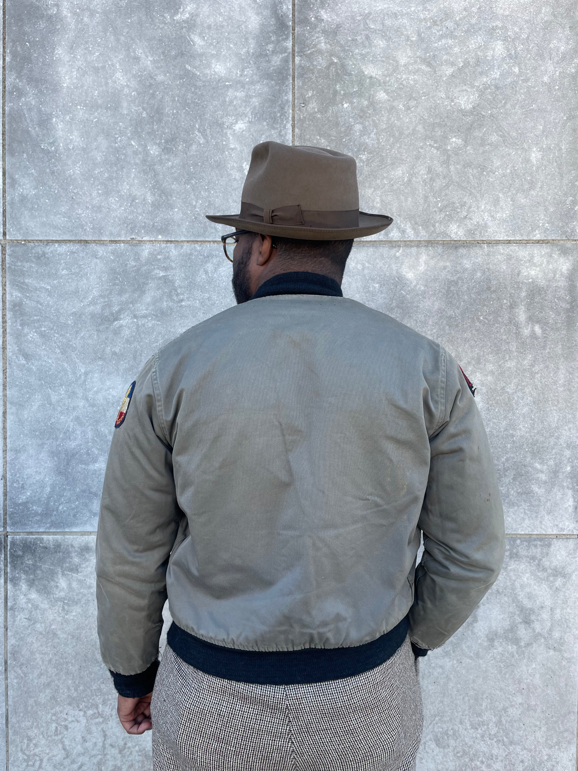 Back view on the model showing the back, knit waistband and a patch on each upper sleeve