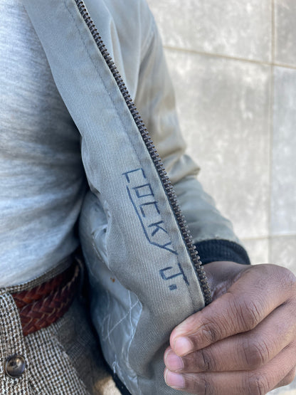 Inside front edge of the jacket by the zipper, with handwritten ink lettering